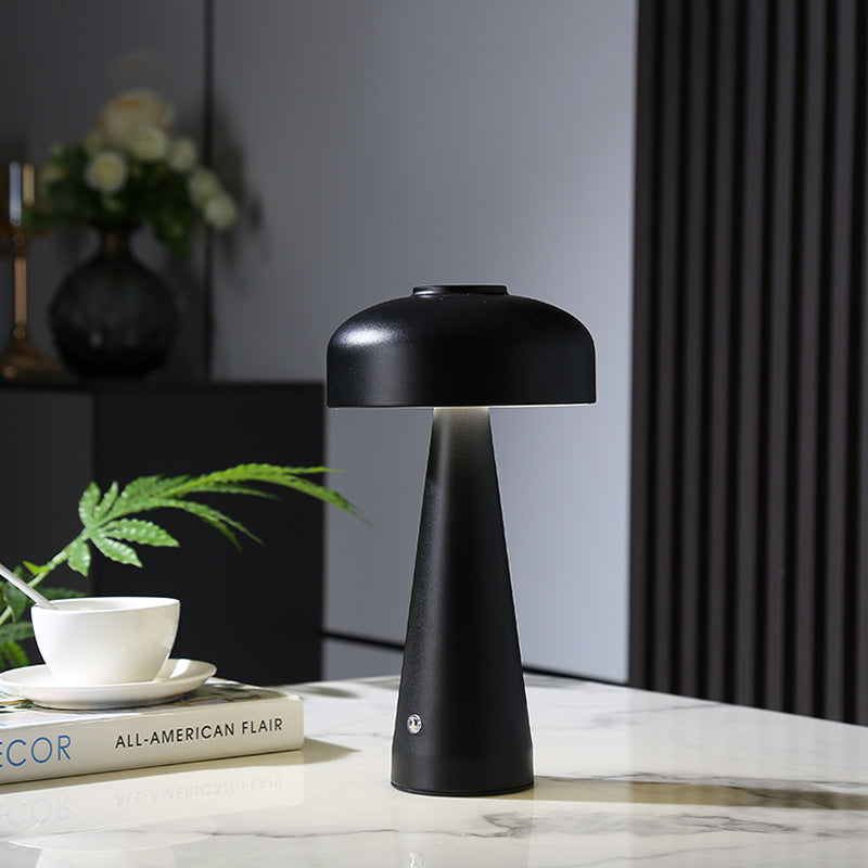 Cordless mushroom table lamp glowing on a bedside table