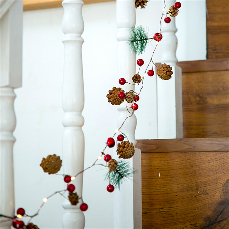 Pine cone and berry fairy lights on a staircase