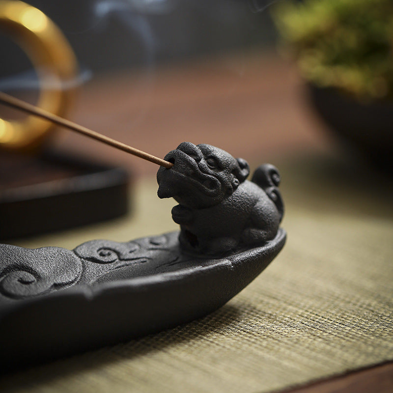 Guardian lion detail on the black ceramic incense stick holder