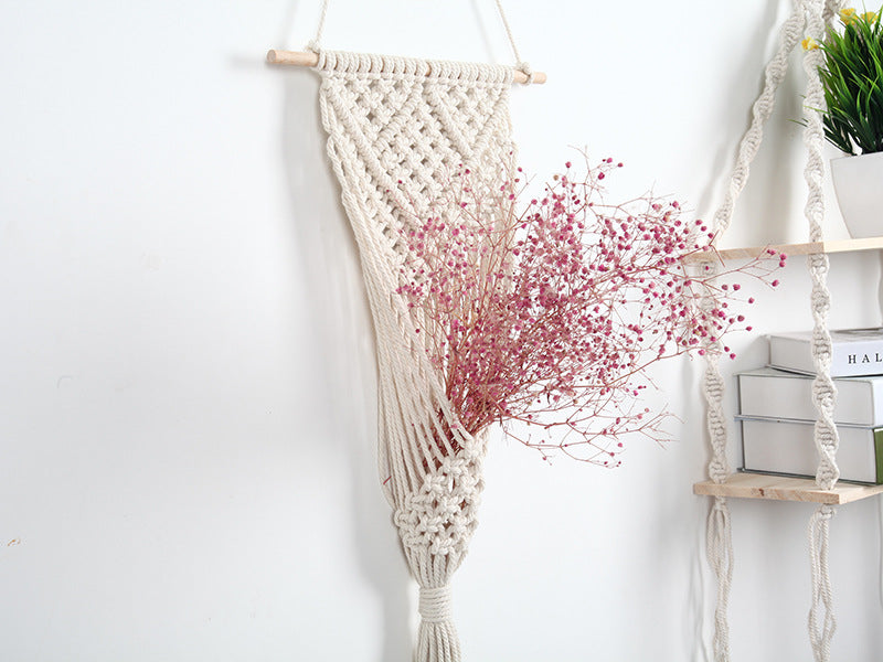 Lifestyle view of the Cream Macramé Wall Hanging Planter displayed beside a wooden wall shelf