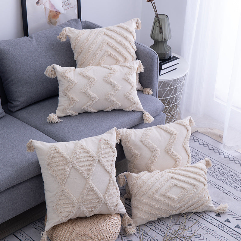 Cream tufted boho cushion covers with corner tassels styled on a grey living room sofa