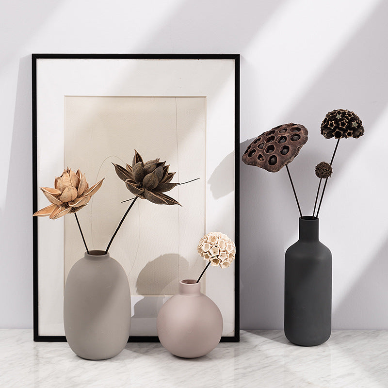 Set of three matte ceramic vases styled with dried lotus pods
