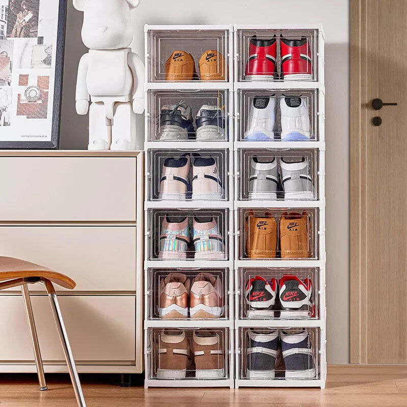 Two white stackable shoe storage towers in a bedroom