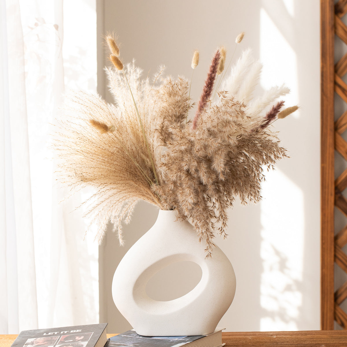 White hollow donut vase holding dried pampas grass
