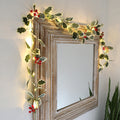 Holly leaf and berry fairy lights around a mirror
